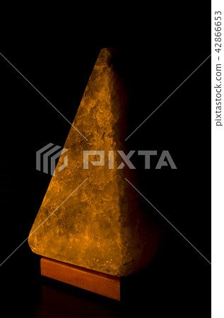 Salt lamp in the form of a pyramid in the darkness Salt lamp in the form of a pyramid in the darkness 42866653