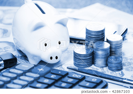Blue theme piggy bank and stack coin on the table Blue theme piggy bank and stack coin on the table 42867103