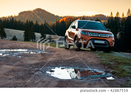 SUV on a country road in mountains at sunrise SUV on a country road in mountains at sunrise 42867559
