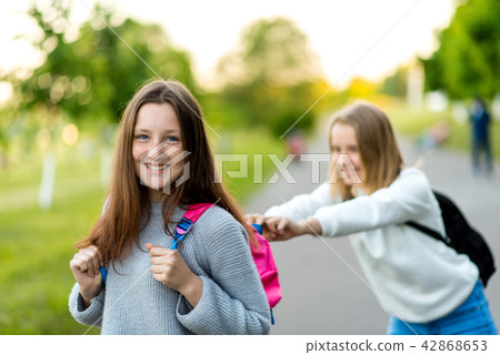 Two girl schoolgirl girlfriends. In the summer in city. Playing with each other. The concept of rest 42868653
