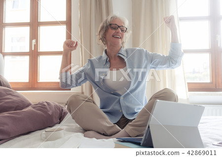 Senior business woman being excited about a success  42869011