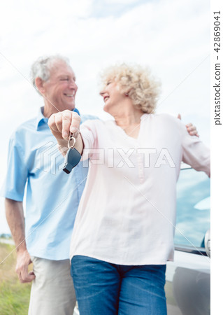 Close-up of the hands of a senior woman showing the keys of her car Close-up of the hands of a senior woman showing the keys of her car 42869041