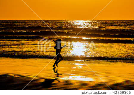 At dusk · Silhouette of a woman running a beach At dusk · Silhouette of a woman running a beach 42869506