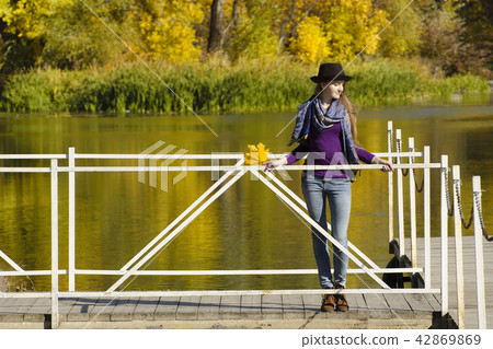 Girl in hat standing on the dock. Autumn, sunny. Girl in hat standing on the dock. Autumn, sunny. 42869869