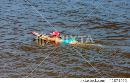 Adorable little girl on surfboard at the seashore Adorable little girl on surfboard at the seashore 42871953