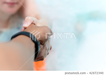 Man hand reach helpnig achild in a local pool on vacation. 42872340
