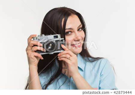 Photographer, hobby and people concept - Young brunette woman with retro camera on white background Photographer, hobby and people concept - Young brunette woman with retro camera on white background 42873444