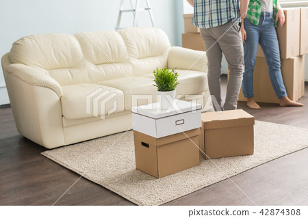 moving boxes on carpet infront of young couple and sofa moving boxes on carpet infront of young couple and sofa 42874308