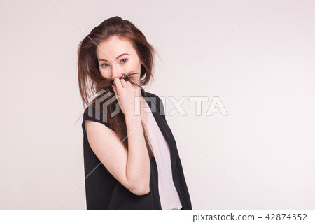 Brunette shy smiling asian woman on a white background with copy space 42874352