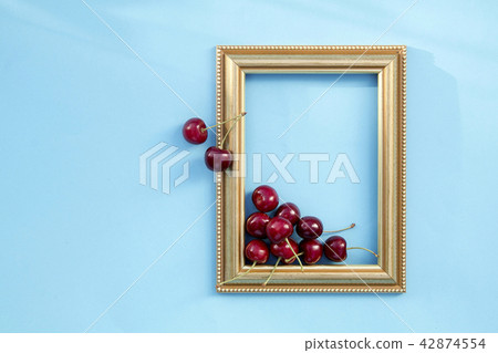 Fresh sweet cherries in frame on blue background Fresh sweet cherries in frame on blue background 42874554