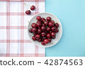 Fresh sweet cherries bowl, napkin on blue background 42874563