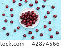 Fresh sweet cherries bowl on blue background 42874566