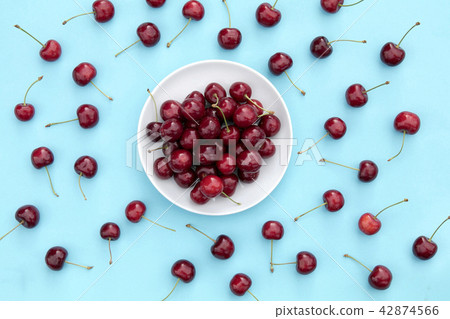 Fresh sweet cherries bowl on blue background Fresh sweet cherries bowl on blue background 42874566