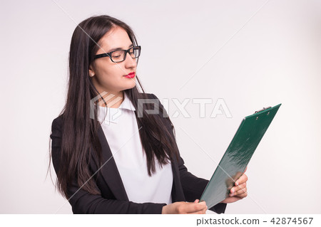 Young business woman wearing glasses, holding paper folder on white background Young business woman wearing glasses, holding paper folder on white background 42874567