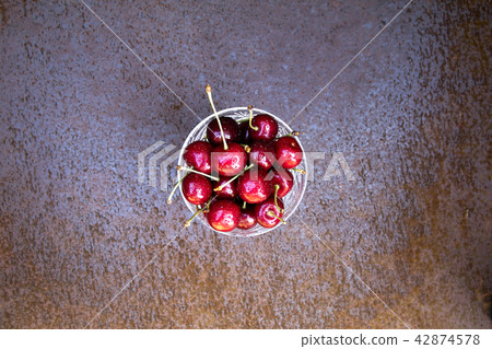 Fresh sweet cherries bowl on grunge rust background 42874578