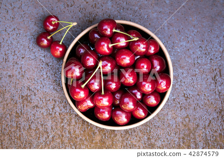 Fresh sweet cherries bowl on grunge rust background Fresh sweet cherries bowl on grunge rust background 42874579