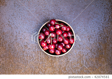 Fresh sweet cherries bowl on grunge rust background Fresh sweet cherries bowl on grunge rust background 42874581