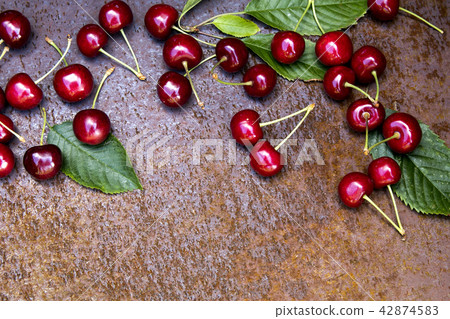 Fresh sweet cherries bowl with leaves on grunge rust background Fresh sweet cherries bowl with leaves on grunge rust background 42874583