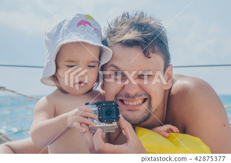 A man takes a little child with a camera A man takes a little child with a camera 42875377