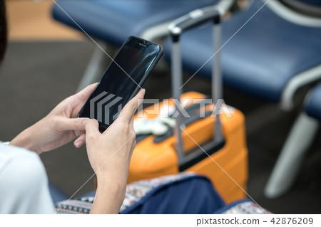 Young traveler woman, using smartphone at airport Young traveler woman, using smartphone at airport 42876209