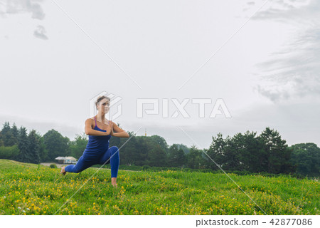Dark-haired woman doing her morning routine enjoying yoga time Dark-haired woman doing her morning routine enjoying yoga time 42877086