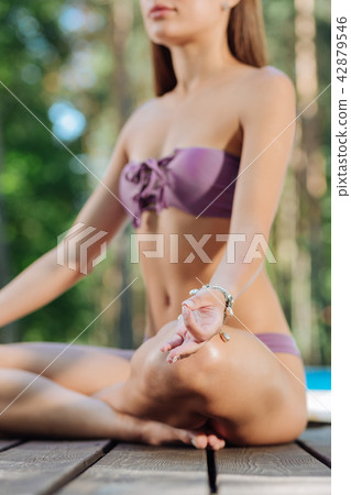 Stylish athletic woman meditating sitting in nature Stylish athletic woman meditating sitting in nature 42879546