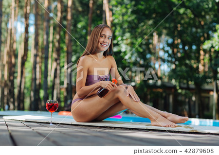 Slim model wearing swimming suit getting suntan in countryside Slim model wearing swimming suit getting suntan in countryside 42879608