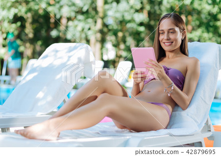 Blue-eyed businesswoman having video chat with partner near pool Blue-eyed businesswoman having video chat with partner near pool 42879695