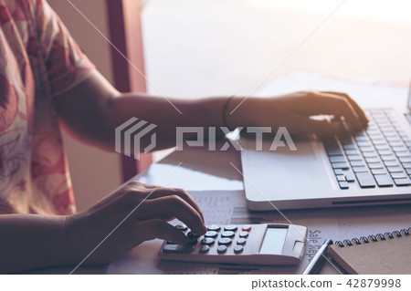 close up woman using calculator and laptop on close up woman using calculator and laptop on 42879998