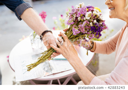 Mature female hands grabbing flowers 42883243