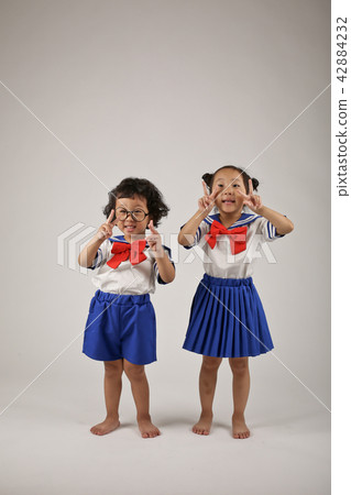 Two kids standing in uniform Two kids standing in uniform 42884232