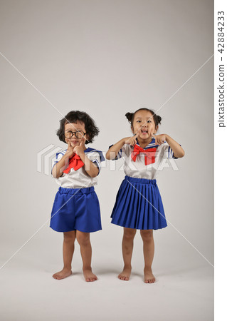 Two kids standing in uniform Two kids standing in uniform 42884233
