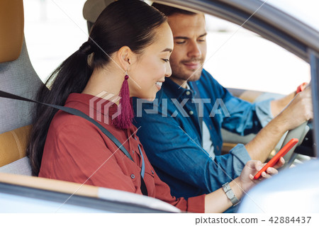 Delighted Asian woman using her smartphone Delighted Asian woman using her smartphone 42884437