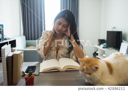 Stressed woman reading book in house Stressed woman reading book in house 42886211