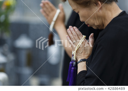 A woman visiting a grave 42886489