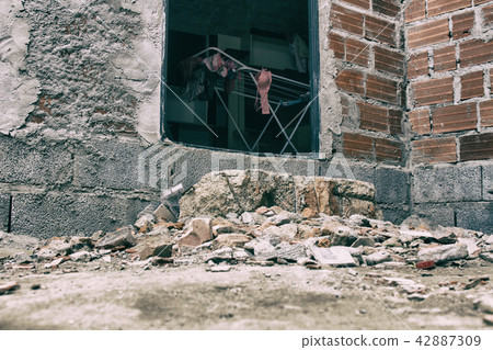Girl clothes hanged to dry inside a poor house. 42887309