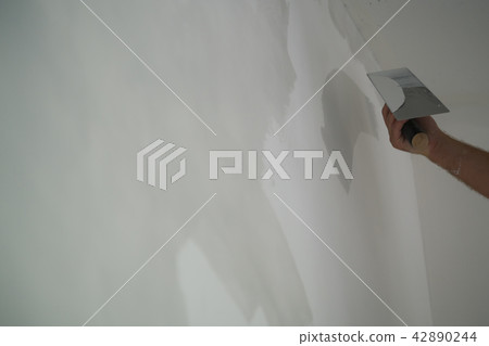 worker applying decorative concrete plaster on the wall 42890244