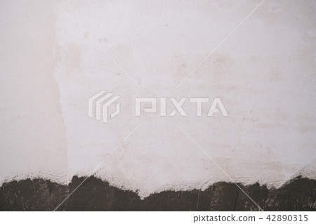 freshly plastered interior wall with mortar on the bottom 42890315