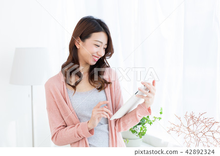 觀看一種片劑的婦女在屋子裡 觀看一種片劑的婦女在屋子裡 42892324