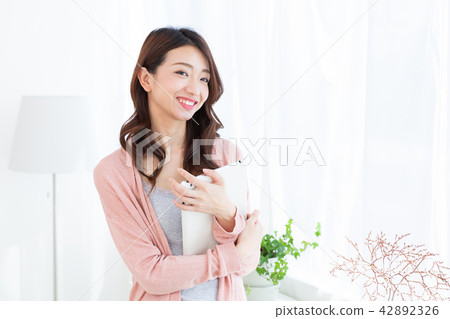 觀看一種片劑的婦女在屋子裡 42892326