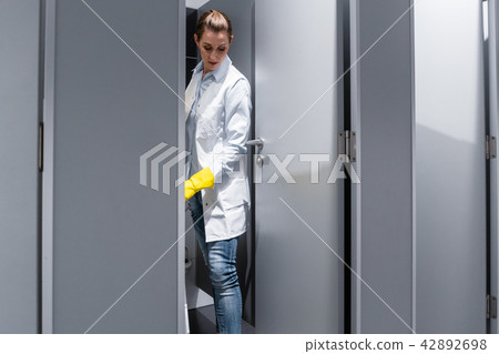 Cleaning lady or janitor mopping the floor in restroom Cleaning lady or janitor mopping the floor in restroom 42892698