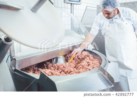 Butcher checking minced meat for the right quality 42892777