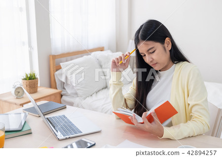 Asian female freelancer headache and stress 42894257