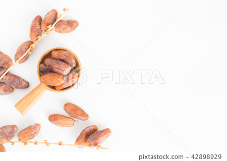 Dates fruit in wooden ladle on white background Dates fruit in wooden ladle on white background 42898929