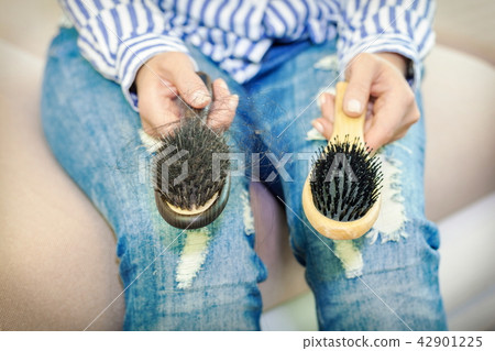 Woman with two comb in hands.Hair loss concept Woman with two comb in hands.Hair loss concept 42901225