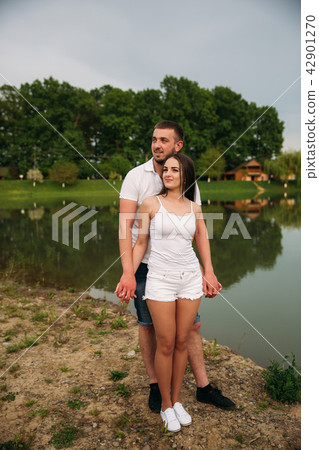 Couple in love hug each other near the lake 42901270