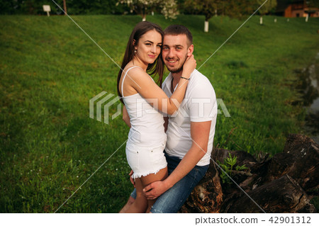 Dating in park. Love couple standing together on grass near the lake. Romance and love Dating in park. Love couple standing together on grass near the lake. Romance and love 42901312