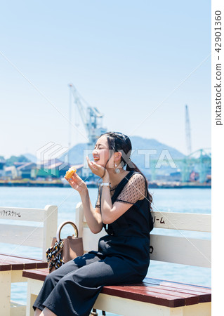 A woman eating ice monaka on the bench A woman eating ice monaka on the bench 42901360