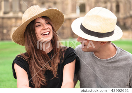 Young fit couple sit together wearing straw hats Young fit couple sit together wearing straw hats 42902661