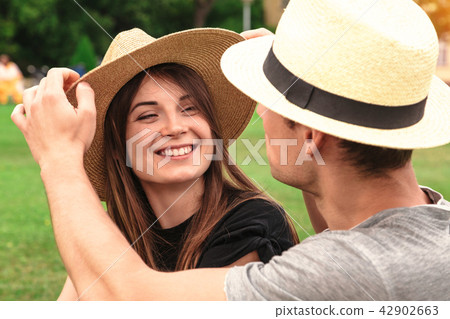 Young fit couple sit together wearing straw hats Young fit couple sit together wearing straw hats 42902663